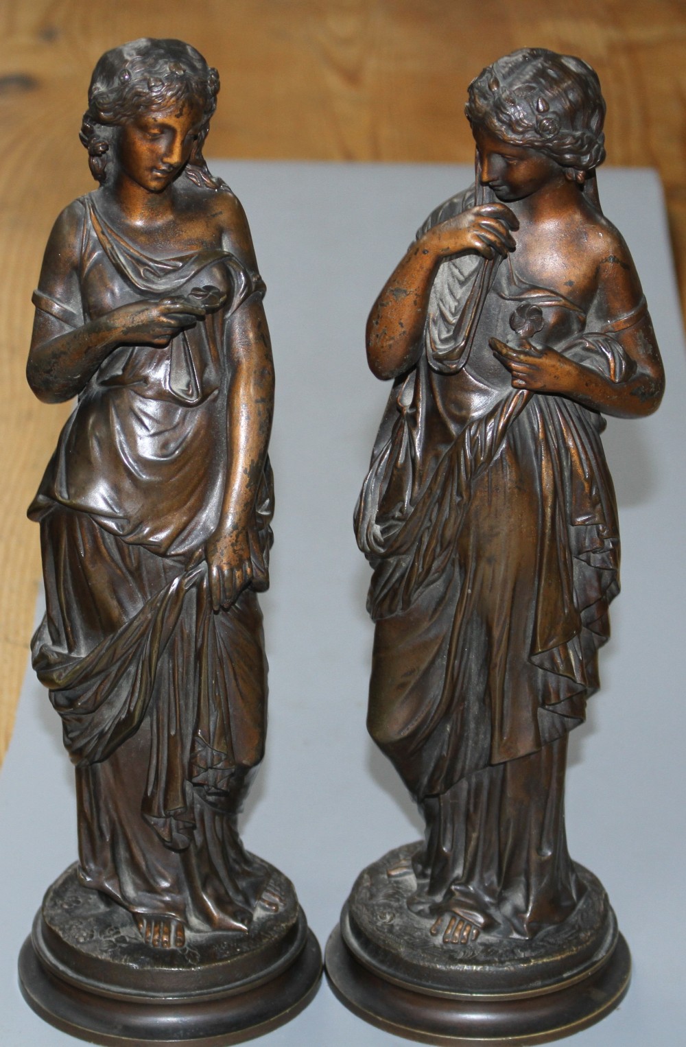 A pair of late 19th century French bronze figures of muses, each standing holding flowers, height 31cm